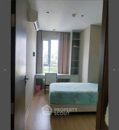 Cozy bedroom with city view, featuring a comfortable bed and study desk, perfect for urban living.