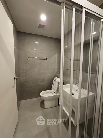 Modern bathroom with sleek design and glass partition in a contemporary apartment.