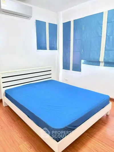 Bright bedroom with blue accents and modern air conditioning unit