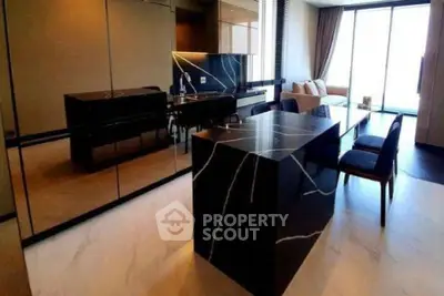 Luxurious modern kitchen with sleek black marble island and elegant dining area.