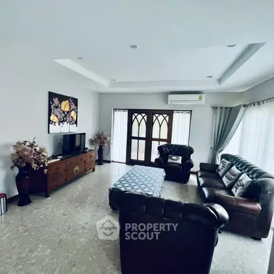 Spacious living room with elegant leather sofas and large windows for natural light.