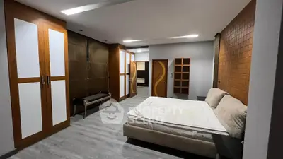 Spacious modern bedroom with stylish wood accents and ample storage space.