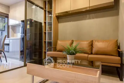 Modern living room with sleek furniture and open kitchen layout in a stylish apartment.