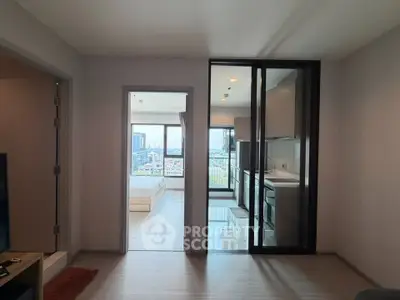 Modern apartment interior with open kitchen and city view from bedroom