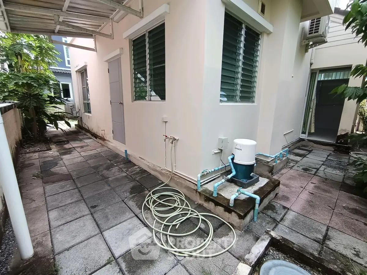 Charming exterior view of a modern home with tiled walkway and lush greenery.