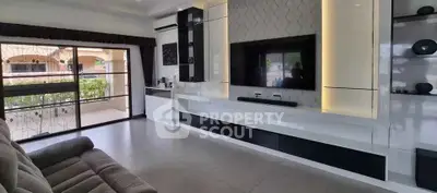 Spacious modern living room with sleek entertainment unit and large window view.