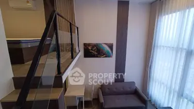 Modern loft apartment with mezzanine, stylish decor, and large windows for natural light.
