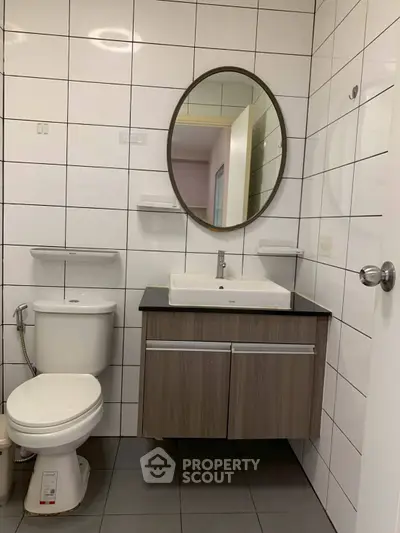 Modern bathroom with sleek fixtures and round mirror