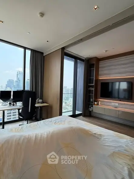 Luxurious bedroom with stunning city view, modern decor, and built-in entertainment center.