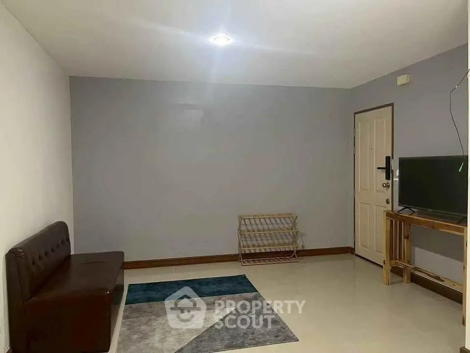 Spacious living room with modern decor and ample natural light.