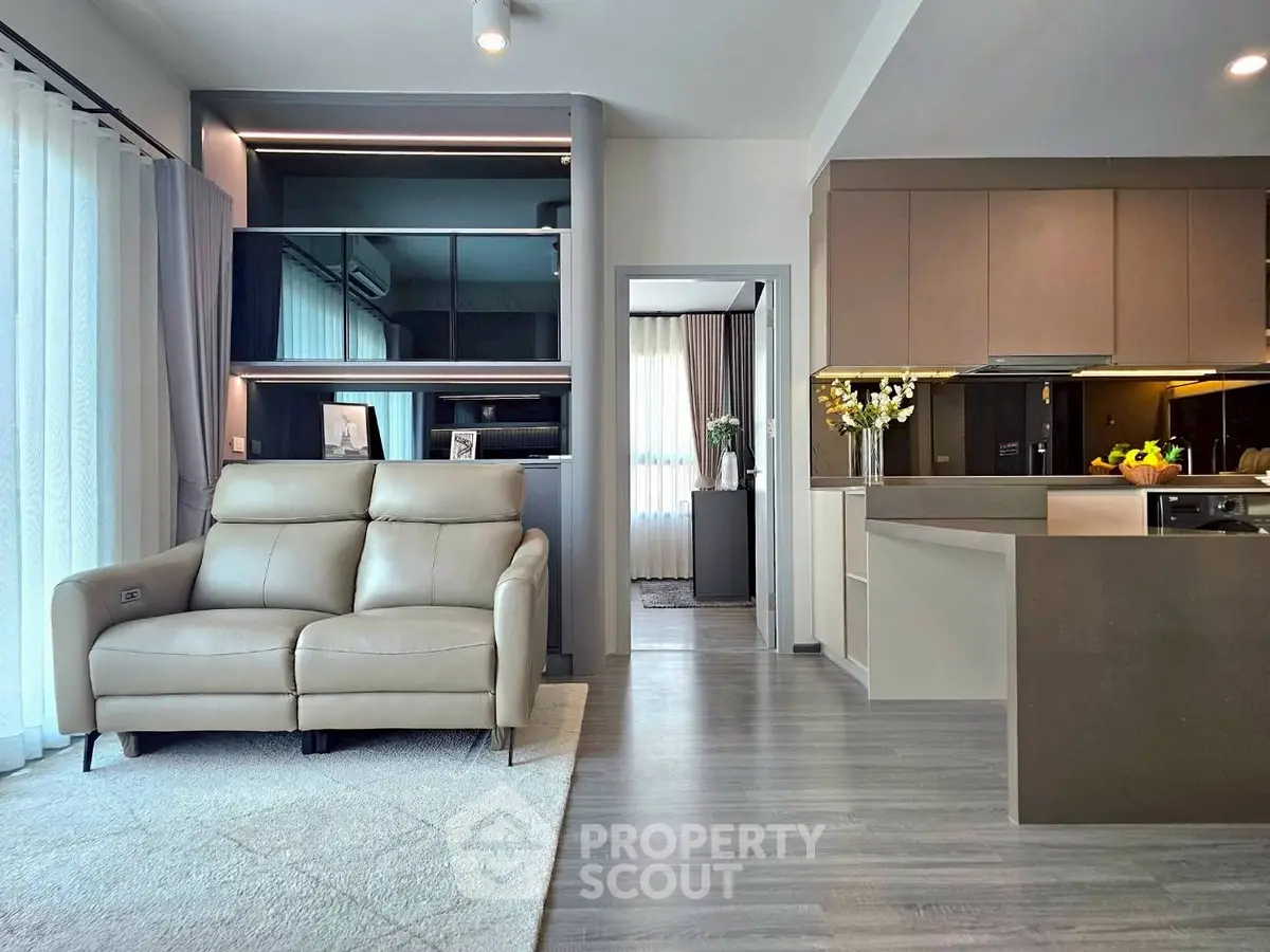 Modern open-plan living room with sleek kitchen and cozy seating area