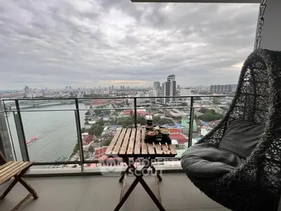 Stunning high-rise balcony with panoramic city and river views, featuring cozy seating.