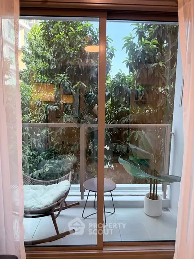 Charming balcony with lush greenery view, featuring cozy seating and modern design, perfect for relaxation.