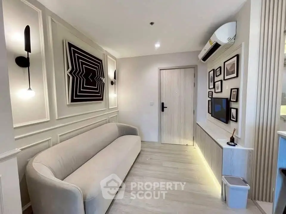 Modern living room with stylish decor and wall-mounted TV, featuring a cozy sofa and elegant lighting.