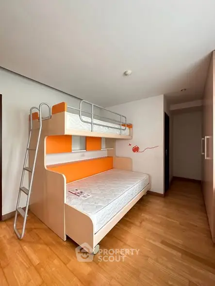 Modern bedroom with stylish bunk bed and wooden flooring, perfect for maximizing space in urban living.