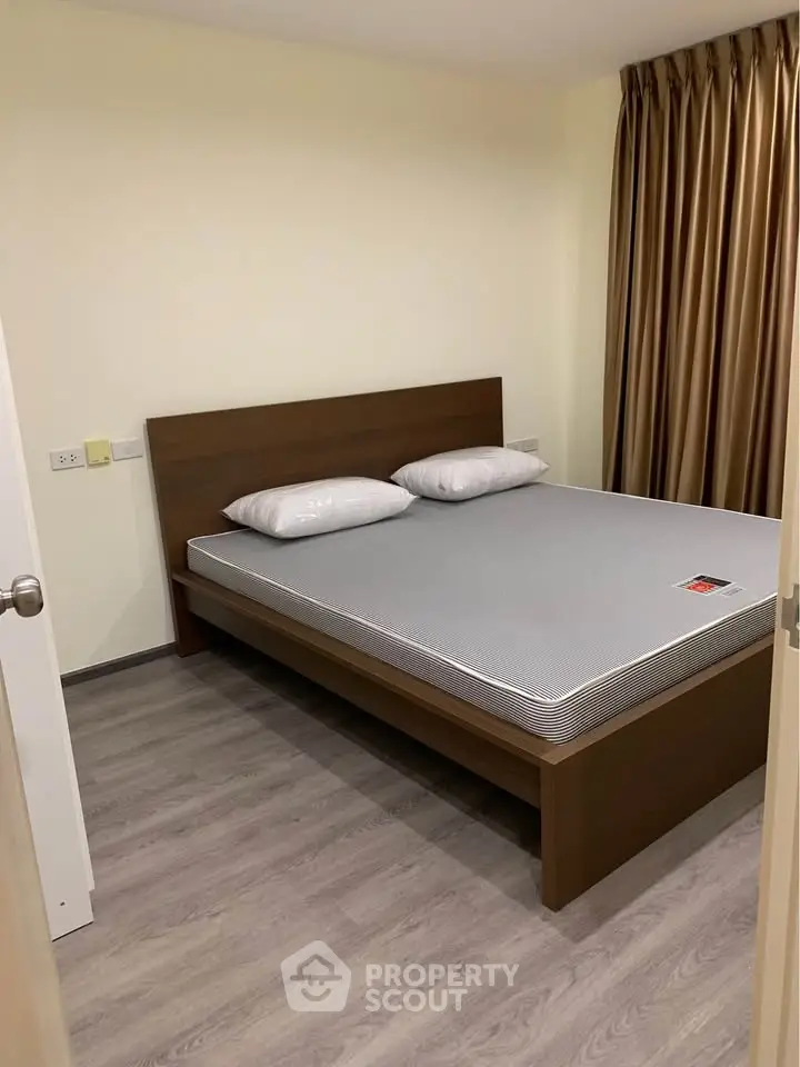 Cozy bedroom with modern wooden bed and elegant curtains, perfect for restful nights.