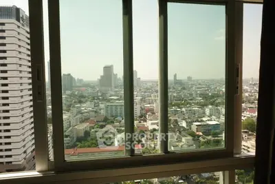 Stunning cityscape view from high-rise apartment window, showcasing urban skyline and modern architecture.