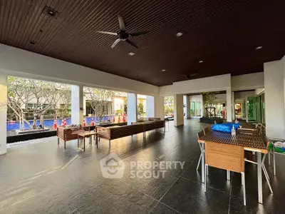 Spacious outdoor area with modern seating and ceiling fans, perfect for relaxation and gatherings.