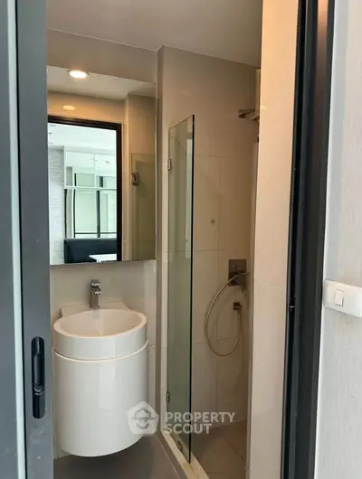 Modern compact bathroom with sleek fixtures and glass shower enclosure