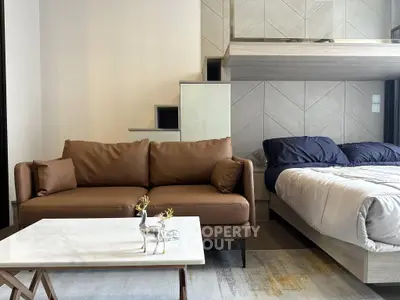 Modern studio apartment with stylish sofa and cozy bed, featuring elegant decor and contemporary design.