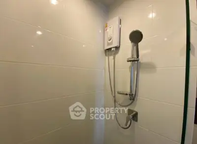 Modern bathroom shower with sleek white tiles and electric water heater