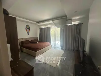 Spacious bedroom with modern decor and large window for natural light.