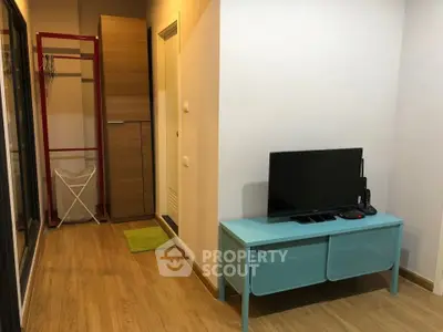 Modern apartment interior with wooden flooring and compact TV setup