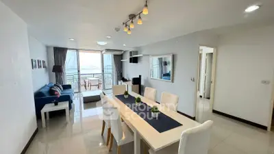 Spacious open-plan living and dining area with modern decor and balcony view.