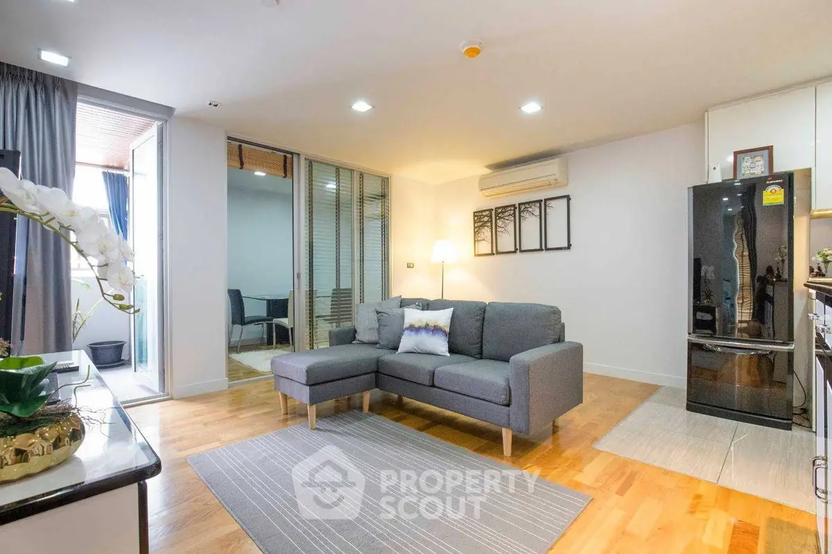 Modern living room with sleek gray sofa, stylish decor, and open balcony access for a bright, airy feel.