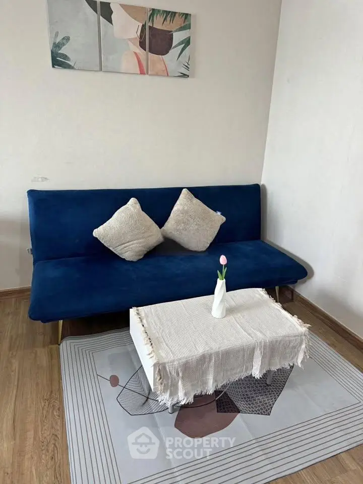 Chic living room with blue sofa, stylish decor, and cozy ambiance.