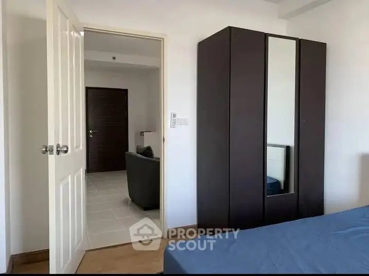 Modern bedroom with sleek wardrobe and open door to living area