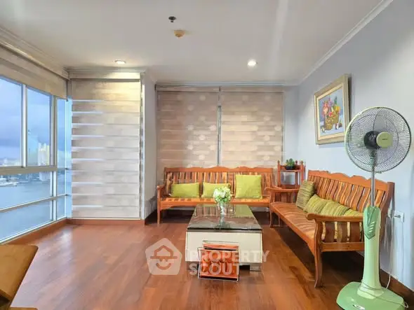 Spacious living room with wooden flooring and panoramic city view.