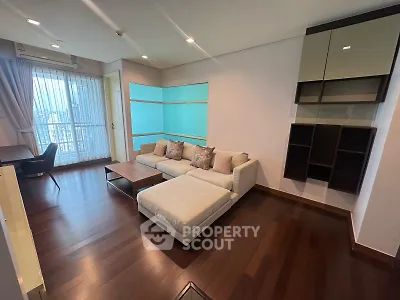 Spacious modern living room with elegant hardwood floors and large windows offering natural light.
