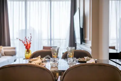 Elegant dining area with modern decor and large windows in a luxurious apartment.