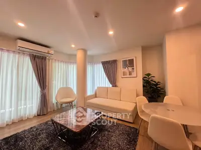 Modern living room with elegant furniture and natural light, featuring a cozy sofa and stylish decor.
