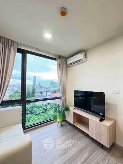 Modern living room with city view, featuring sleek furniture and large windows for natural light.