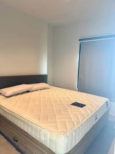 Spacious bedroom with a comfortable bed and natural light, perfect for relaxation.