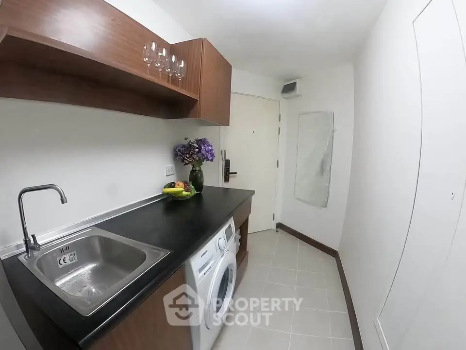 Modern laundry room with sleek cabinetry and washing machine in a compact space.