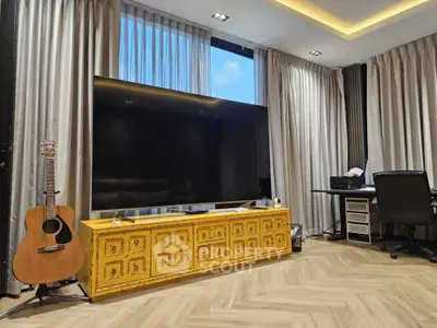 Stylish living room with large TV, guitar, and modern decor