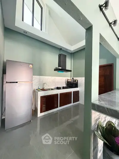 Modern kitchen with high ceiling and sleek appliances in a stylish home