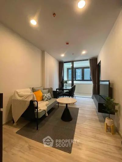 Modern living room with stylish decor and natural light, featuring a cozy sofa and elegant furnishings.