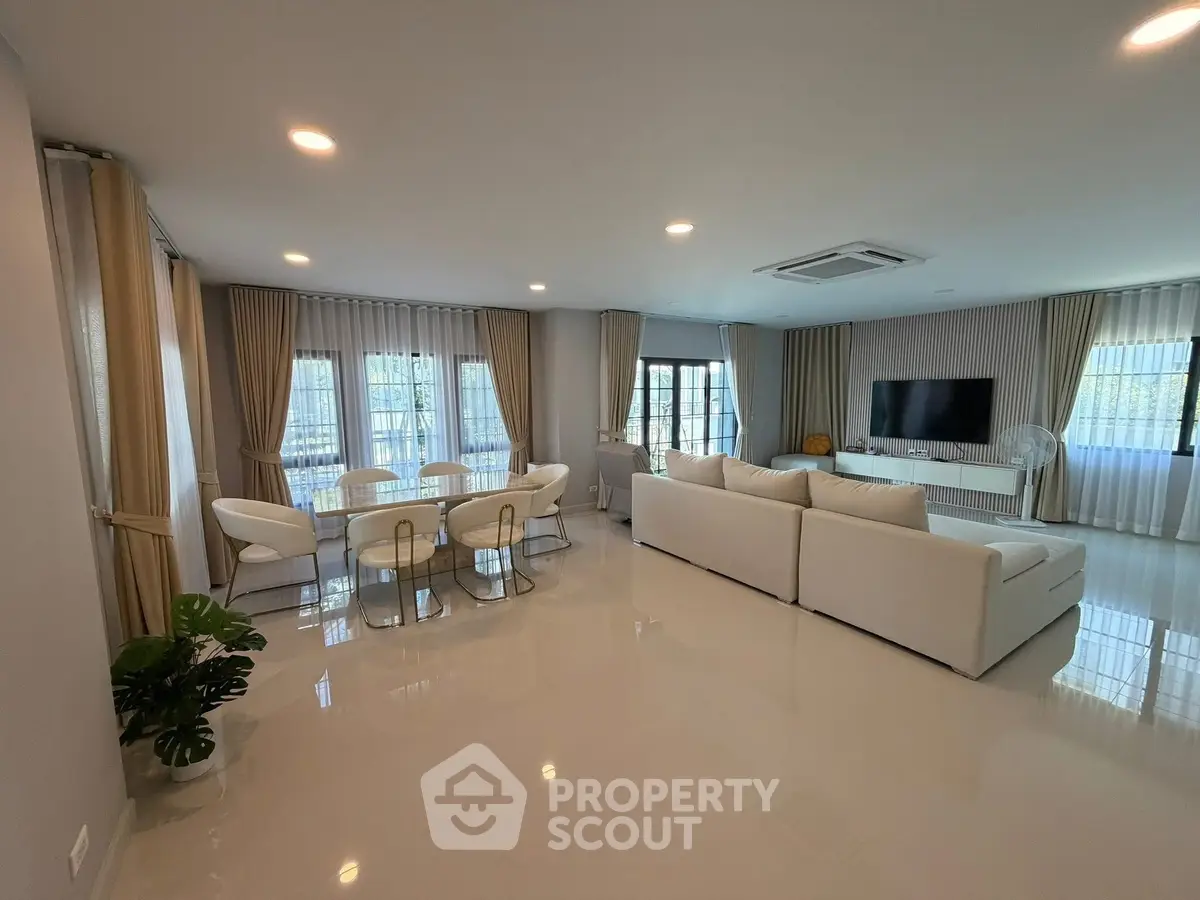 Spacious modern living room with elegant decor and ample natural light, perfect for family gatherings.