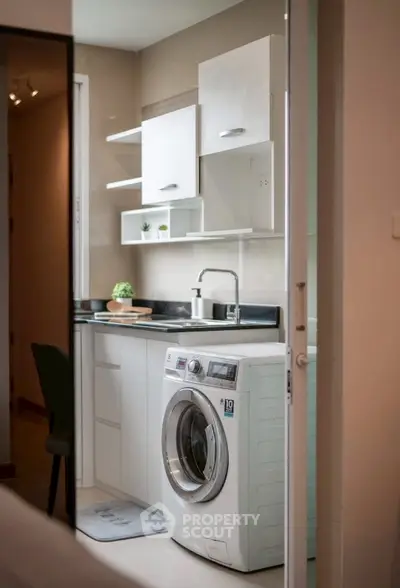 Modern kitchen with sleek cabinetry and integrated washing machine