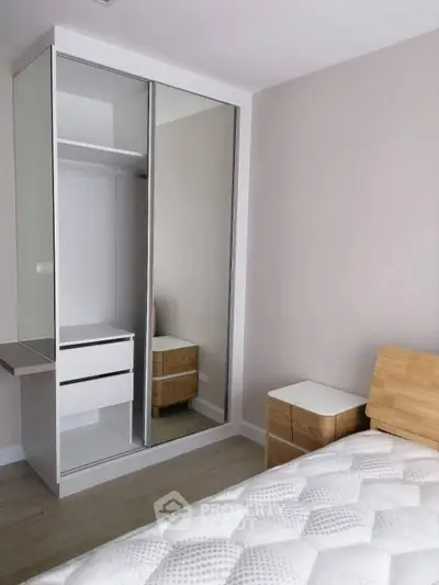 Modern bedroom with sleek mirrored wardrobe and cozy wooden furniture