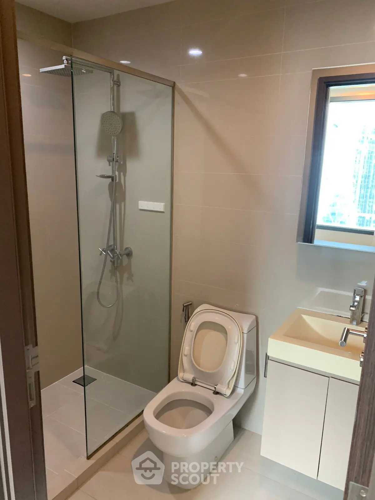 Modern bathroom with glass shower and sleek fixtures in a contemporary apartment.