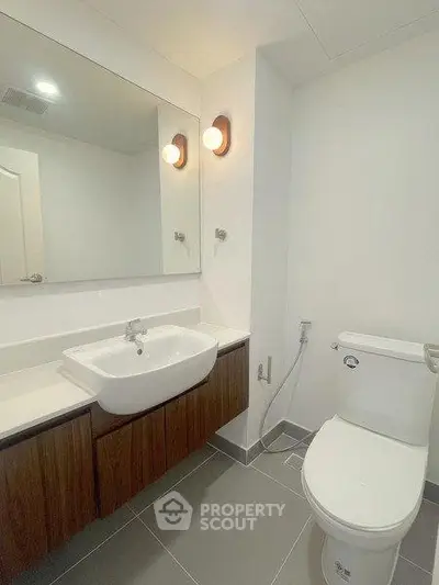 Modern bathroom with sleek fixtures and contemporary design, featuring a spacious sink and elegant lighting.