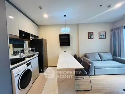 Modern open-layout kitchen and living room with stylish furniture and appliances.