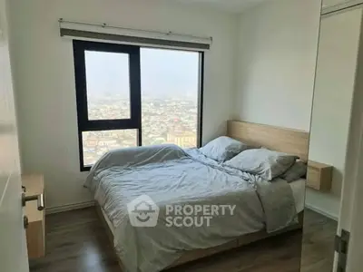 Cozy bedroom with city view, featuring a comfortable bed and modern decor.