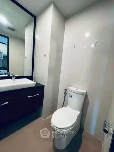Modern bathroom with sleek fixtures and large mirror in a contemporary home.