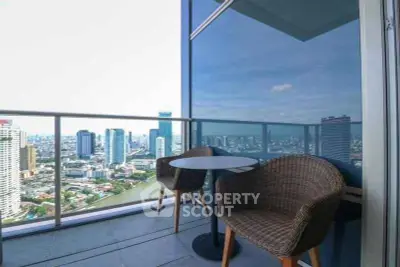 Stunning high-rise balcony with panoramic city views and cozy seating area.